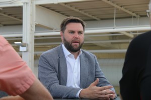 J. D. Vance wears a grey blazer and white button down shirt.