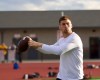 a football player throws a pass during a drill
